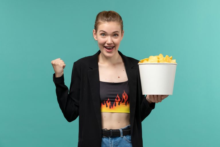 front-view-young-female-holding-chips-watching-movie-blue-surface